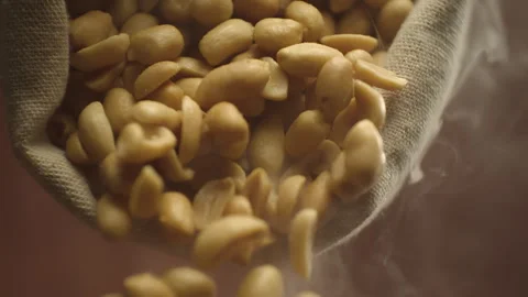 Crispy roasted salted peanuts falling in super slow motion close up. Hot Stock Footage 283070331