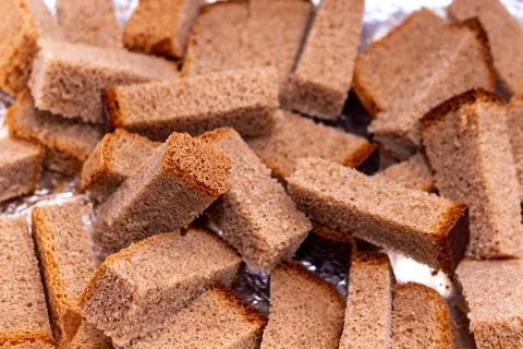 Crispy rye bread croutons for salad and appetizers on a silver background 스톡 사진
