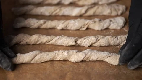 Crispy rye sticks sprinkled with flour. The baker puts the sticks on a baking Stock Footage 159366478
