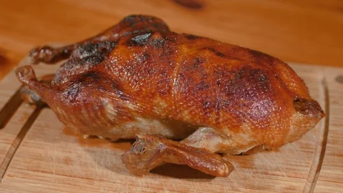 Crispy-Skinned Roast Young Duck Is Cut Along Leg With Sharp Knife. Stock Footage 99426041