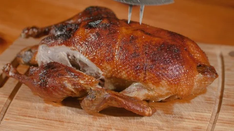 Crispy-Skinned Roast Young Duck Is Slicing Along Breast With Sharp Knife. Stock Footage 99427736