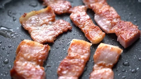 Crispy slices of delicious bacon fried in a hot pan. Pan-fried bacon strips. Stock Footage 220437725