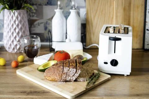 Crispy slices of rye bread peek out of the toaster. Toast for breakfast Stock Photos