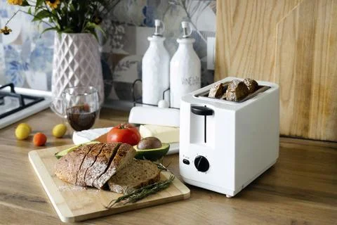 Crispy slices of rye bread peek out of the toaster. Toast for breakfast Stock Photos