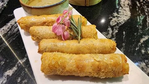 Crispy Spring Rolls Served with Sauce and Fresh Herbs on Plate Stock Photos