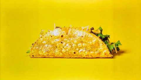 Crispy Taco with Beef, Cheese and Lettuce Isolated on Yellow Background for.. Stock Photos