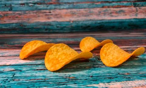 Crispy thin potato chips on a blue background Stock Photos