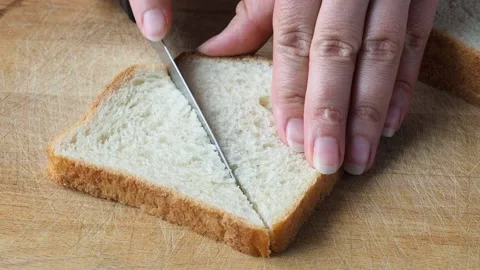 Crispy toast bread is cut on a cutting board for making sandwiches. Video stock 157584219