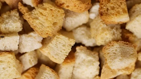 Crispy toasted bread falling down spinning in slow motion. Stock Footage 234717792