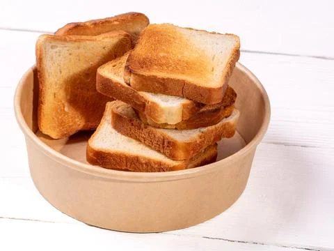Crispy toasted white bread slices arranged on clean white table Stock Photos