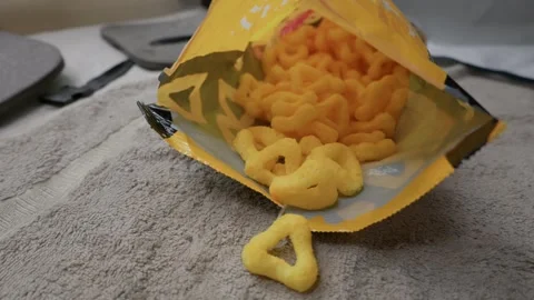 Crispy Triangle Cheese Puff Corn Snacks Spilling from Open Yellow Bag Stock Footage 341993546