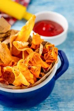 Crispy vegetable chips served with ketchup on blue table Stock Photos