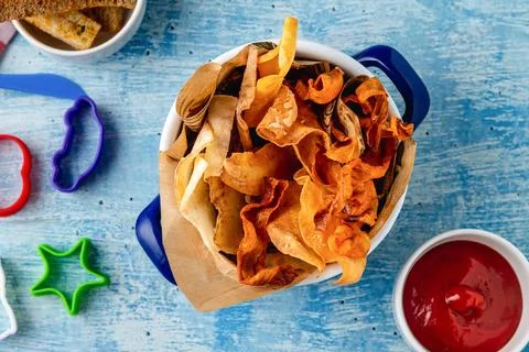 Crispy vegetable chips served with ketchup on blue table Stock Photos