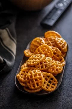 Crispy Waffle Potato Snacks on Plate. Savory Seasoned Chips for Casual Snac.. Stock Photos
