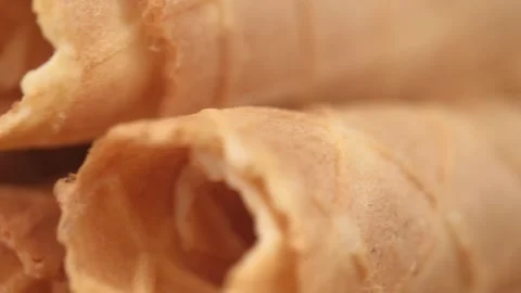 Crispy waffle tubes rotate closeup. sweet waffle rolls. selective focus. macro. Stock Footage 241428736