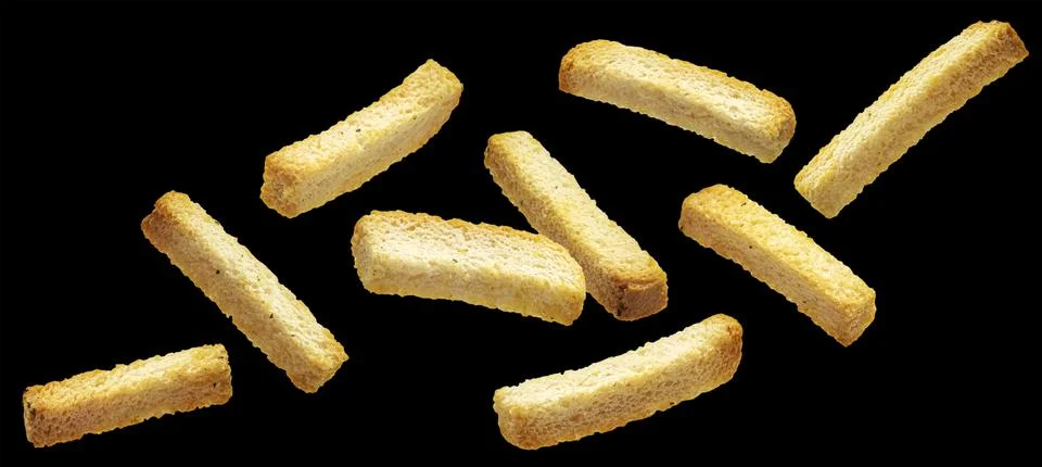 Crispy white bread rusks falling on black background Stock Photos