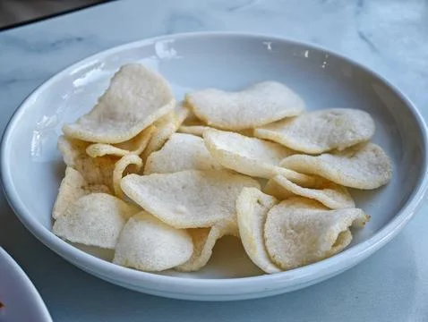 Crispy white fish crackers served in a white bowl Stock Photos