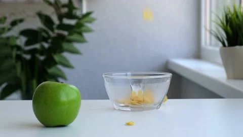 Crispy yellow corn flakes falling into the bowl in the morning for a tasty Stock Footage 158799349