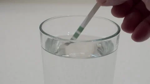 Critical Test: Hand Dips Water Hardness Strip into Glass of Clear Water. 스톡 동영상 321151688