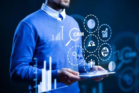 CRM software user interacts with digital data on a tablet in a modern office Stock Photos