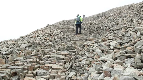 Croagh Patrick - pilgrim climbs last stage to summit of moutain Stock Footage 230988503