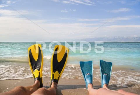 Croatia, Zadar, Couple with flippers relaxing on beach Stock Photos