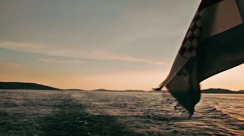 Croatian flag waving in the wind on a back of the ferry boat during sunset Stock Footage 60542369