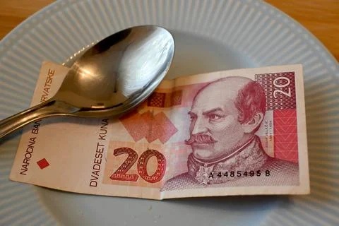 Croatian kuna banknote on plate with spoon Foto stock