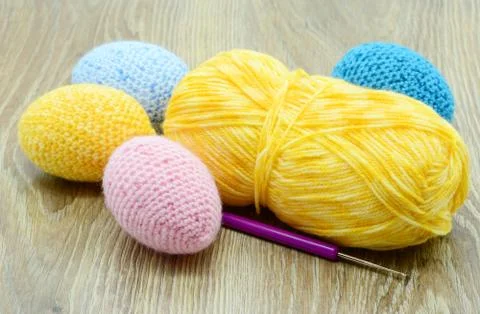 Crochet easter eggs in blue pink yellow on wooden background Stock Photos