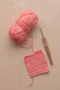 Crochet handmade square pattern, pink yarn coil, hook, knitting crocheting .. Stock Photos