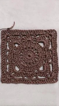 A crochet pattern of brown squares, perfect for home decor and fashion. On a  Stock Photos