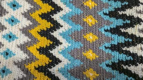 Crochet pattern of multicolored threads. Yellow with gray, black and other co 写真素材