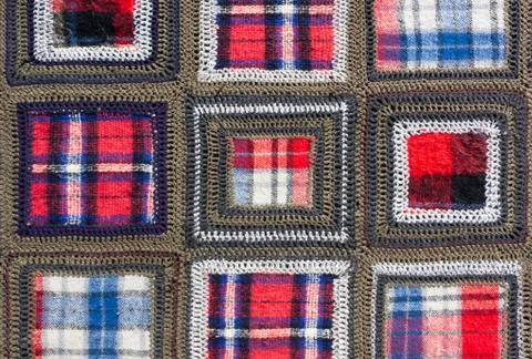 Crochet plaid with checkered inserts as background Stock Photos