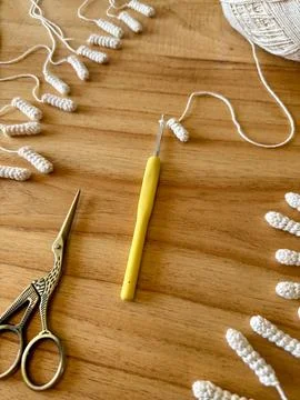 Crochet project in progress with scissors and ball of white yarn Stock Photos