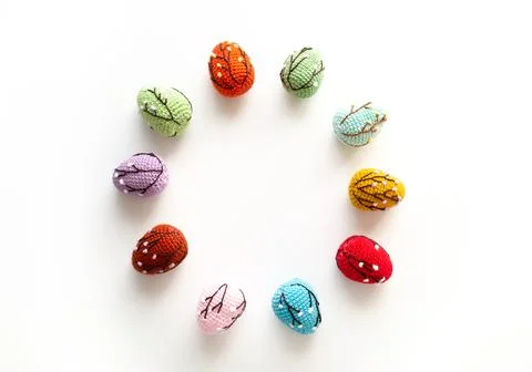 Crocheted colored Easter eggs arranged in a circle on a white background. Top Stock Photos