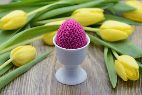 Crocheted easter eggs and a bouquet of yellow tulips Stock Photos