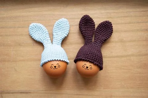 Crocheted Easter eggs with bunny ears on a wooden table. Soft focus Stock Photos