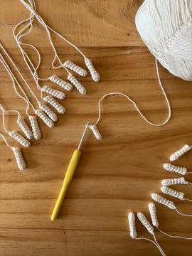 Crocheted elements in progress with yellow hook Stock Photos