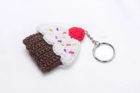Crocheted keychain in the shape of a vanilla and raspberry cupcake Stock Photos