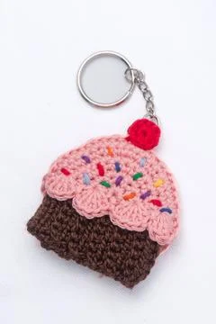 Crocheted keychain in the shape of a vanilla and raspberry cupcake Foto stock