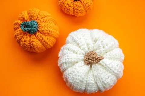 Crocheted pumpkins on orange background for fall concept Stock Photos