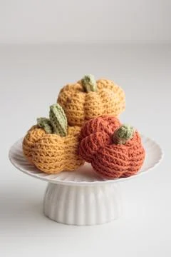 Crocheted pumpkins on a white table Stock Photos