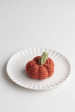 Crocheted pumpkins on a white table Foto stock