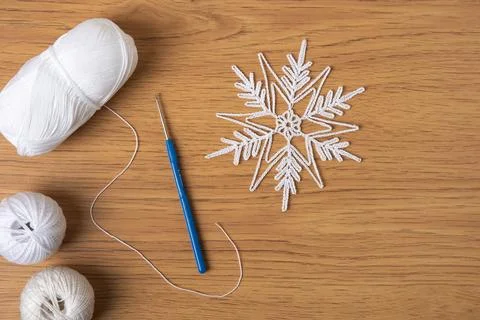 Crocheted snowflake and ball of thread Stock Photos