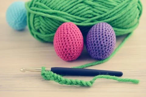 Crocheting easter eggs with blue pink green. wooden table background. Stock Photos