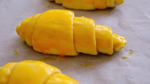 Croissant dough with egg applied to it to be put in the oven Stock Footage 289239597