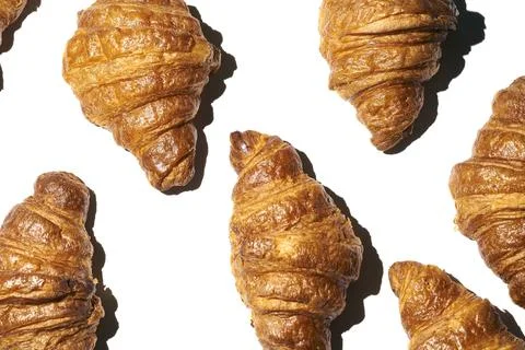 Croissant pattern with hard light on a white background. Many different crois Stock Photos