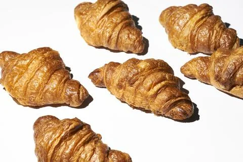 Croissant pattern with hard light on a white background. Many different crois Stock Photos