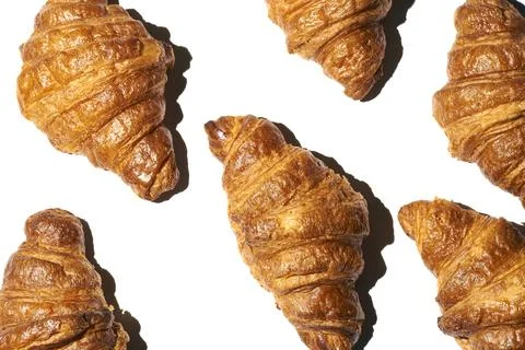 Croissant pattern with hard light on a white background. Many different crois Stock Photos