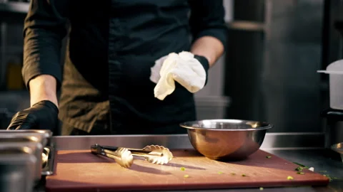 Croissant plan of a professional kitchen a chef in a black jacket wipes kitchen Stock Footage 273167534